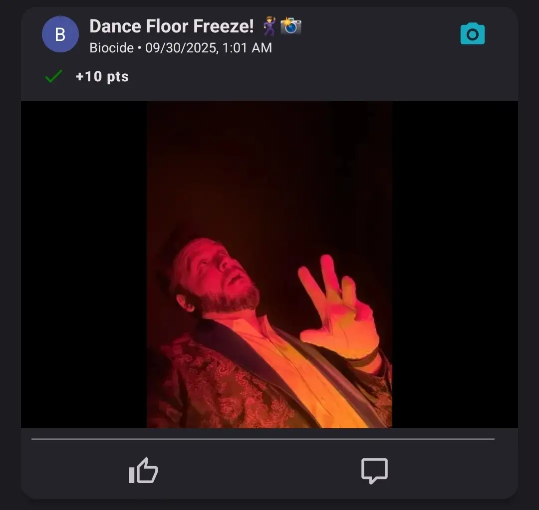 A man frozen mid-pose on a dance floor, lit dramatically by red lighting during a dance challenge