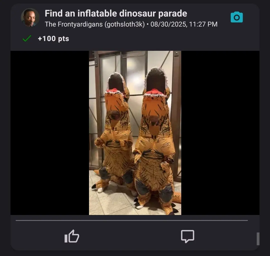 Two people wearing full inflatable T-Rex costumes standing side by side in a hallway